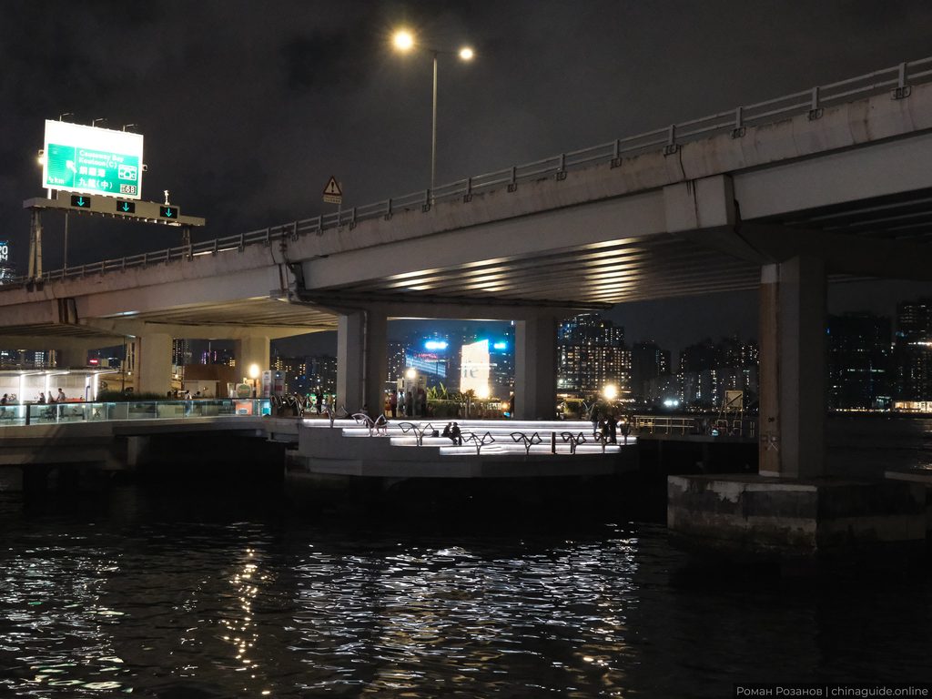 Ночной городской пейзаж с мостом над водой и небоскребами