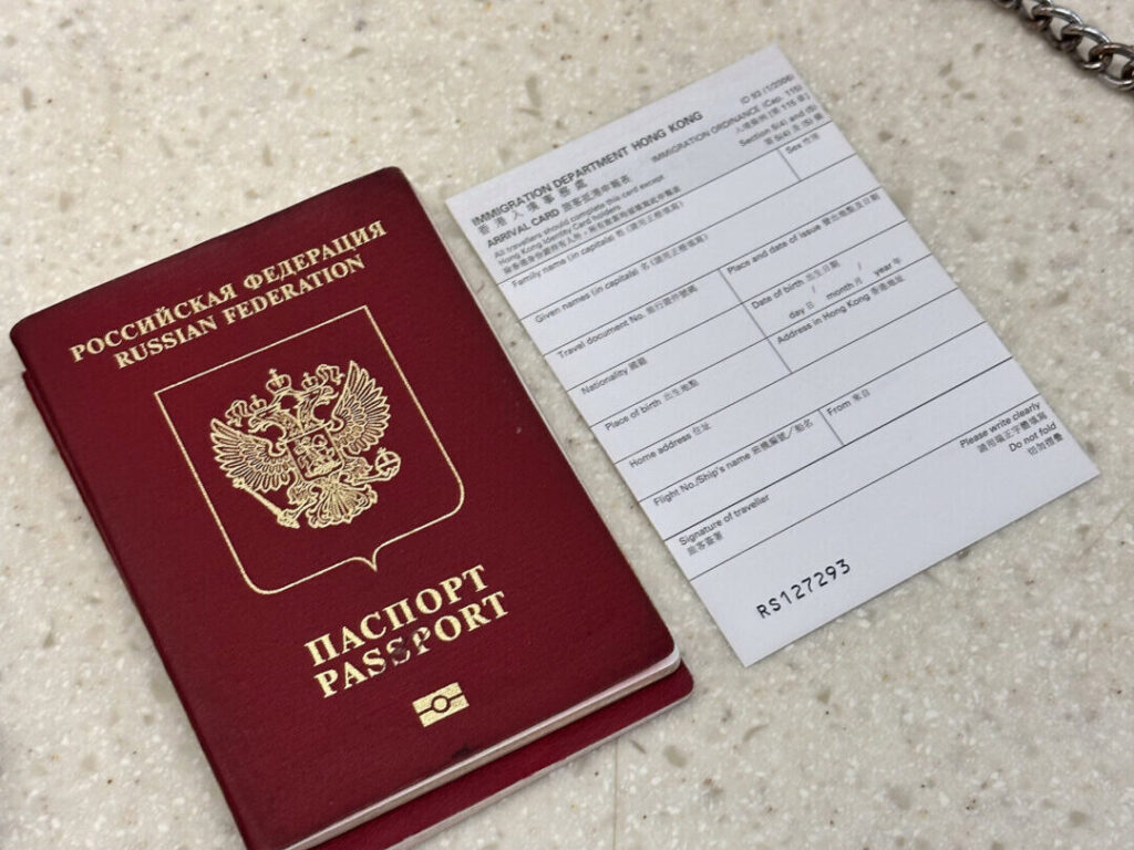 Российский паспорт и иммиграционная форма Гонконга на столе.