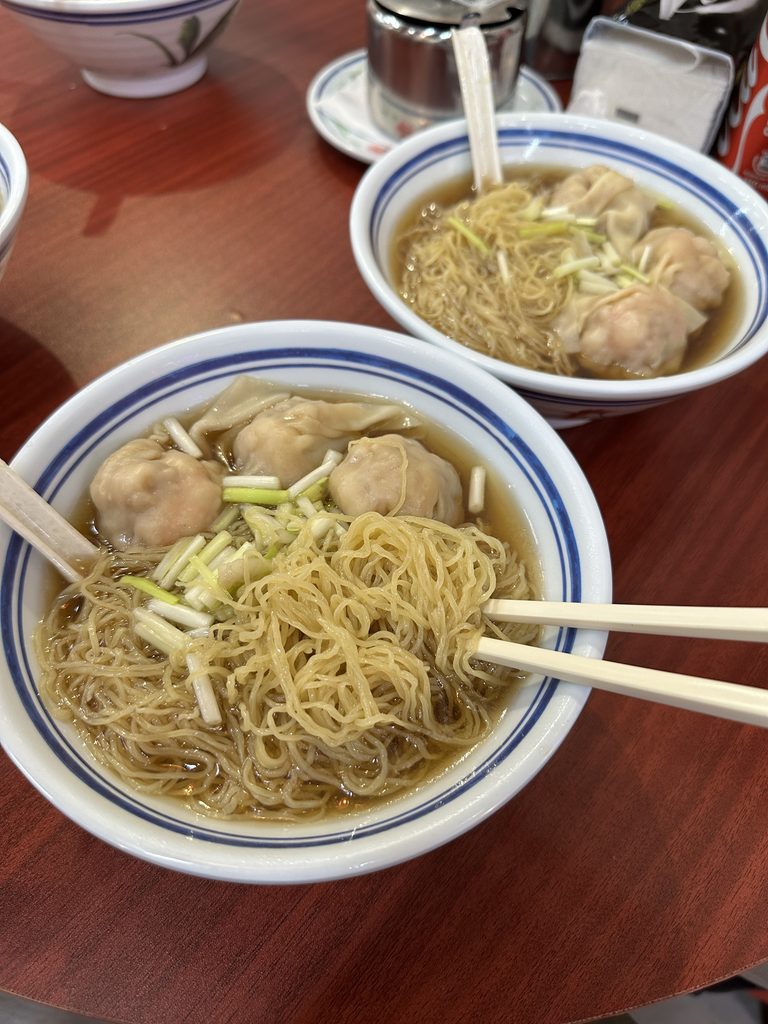 Две миски азиатской лапши с клёцками и палочками