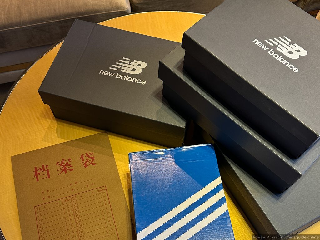 Коробки New Balance и спортивный инвентарь на жёлтом столе