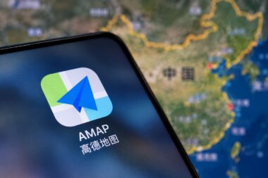 Приложение AMAP на экране смартфона перед картой Китая